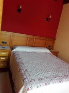 - une chambre avec un lit blanc et un mur rouge dans l'établissement Casa Rural Juaco, à Bimenes