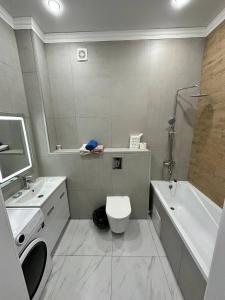 a bathroom with a toilet and a sink and a tub at Dastur in Taldykolʼ