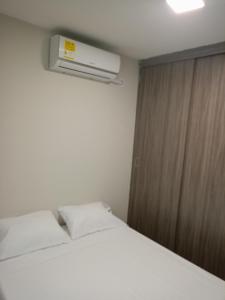 1 dormitorio con 1 cama blanca y aire acondicionado en Excepcional Apartamento, en Valledupar