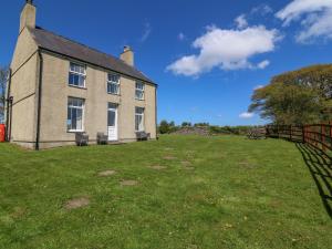 a large house with a fence in front of it at Ty Mawr in Gaerwen