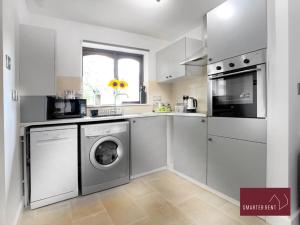 a white kitchen with a washer and dryer in it at Hitchin - St Anne's - 2 bed coach house & Parking in London Colney