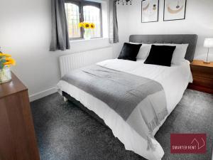 a bedroom with a large white bed and a window at Hitchin - St Anne's - 2 bed coach house & Parking in London Colney