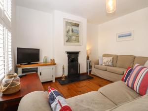 a living room with a couch and a fireplace at Fishermans Cottage in Whitstable