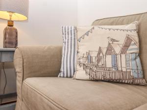a pillow on a chair with a house at Fishermans Cottage in Whitstable
