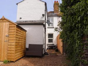 a garage with a chair in it next to a house at Fishermans Cottage in Whitstable