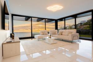 een woonkamer met twee banken en een tafel bij Villa Luxe by Atlantic Holiday in Ribeira Brava