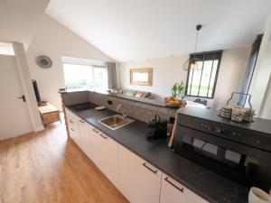 a kitchen with a black counter top and a sink at Wellness Bungalow with whirlpool and sauna in Zevenhuizen