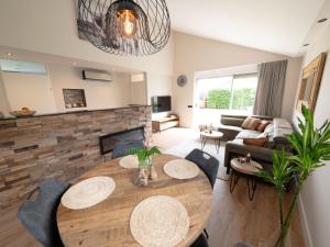 uma sala de estar com uma mesa e uma lareira em Wellness Bungalow with whirlpool and sauna em Zevenhuizen