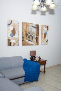 a living room with a couch and paintings on the wall at Casa estilo cabaña “Villa Sol” en Alto Boquete in Boquete