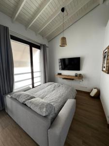 a bedroom with a bed and a tv on the wall at M&M Empedrada Apartamentos Jerez in Jerez de la Frontera