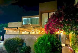 a house with a bunch of flowers in front of it at 10 Room ScottsdaleResortVillas by AmericanVacationliving in Scottsdale