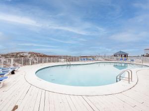 a large swimming pool with chairs and a wooden deck at Sugar Beach 301 by Vacation Homes Collection in Gulf Shores