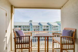 a balcony with chairs and a table and a view of a building at Sugar Beach 301 by Vacation Homes Collection in Gulf Shores