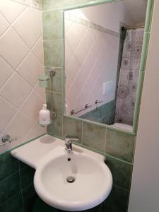 uma casa de banho com um lavatório branco e um espelho. em La Casina di Anna em Porto Vecchio