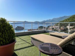 a balcony with a couch and a view of the ocean at Guest house Villa Slavica in Sveti Stefan
