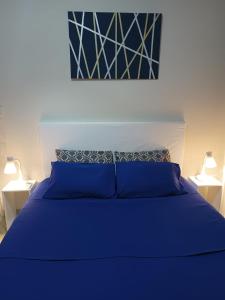 een blauw bed in een slaapkamer met 2 lampen bij Beachfront apartment Encarnacion in Encarnación +18 foto's