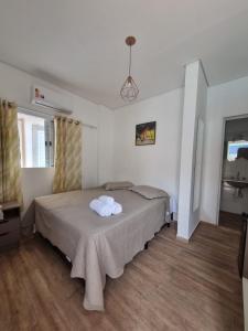 een slaapkamer met een bed met twee handdoeken erop bij Pousada Aconchego na Praia in Praia Grande