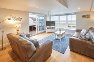 a living room with two couches and a television at Turnstone Cottage in Whitby