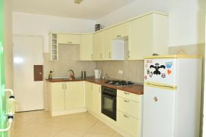 a kitchen with white cabinets and a white refrigerator at Private surf house & garden, v near beach & town in Santa Maria