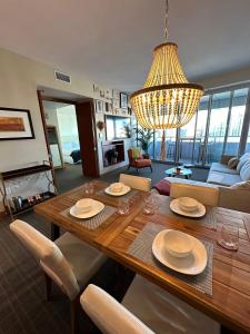 a living room with a wooden table and a chandelier at Brickell Floor 31 Sea View-Free Parking by Palermo Home Miami in Miami