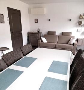 Zimmer mit einem Tisch, Stühlen und einem Sofa in der Unterkunft Vakantiewoning De Reünie in Langemark