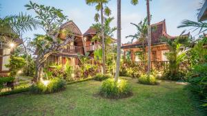 einen Blick nach außen auf ein Haus mit Palmen in der Unterkunft Picturesque Private Joglo Villa Near Monkey Forest in Ubud