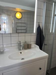 a bathroom with a white sink and a mirror at Korsvirkeslänga in Helsingborg
