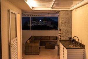 een woonkamer met een bank bij Serena Beach Triplex in Caraguatatuba