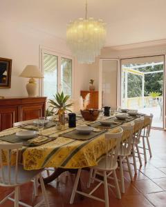 a dining room with a table with chairs and a chandelier at Villa Barelli in Cabris