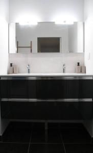 a bathroom with two sinks and a large mirror at Flik-en-flac - Appartement à 20m de la plage in Roscoff