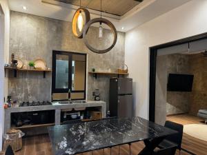 een keuken met een zwarte tafel en een koelkast bij Penthouse kavali in Los Ayala
