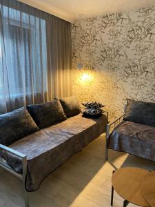 a living room with a couch and a table at Losiku apartamenti in Ventspils