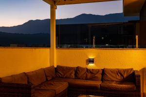 een bank in een kamer met uitzicht op de bergen bij Serena Beach Triplex in Caraguatatuba