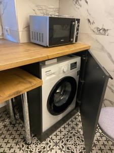 a microwave and a washer and dryer on a table at Losiku apartamenti in Ventspils
