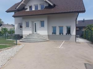 a white house with stairs and a door at SPRING APT with garden and FREE secure parking in Domžale