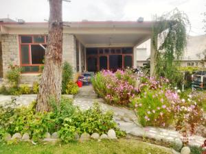 une maison fleurie dans la cour avant dans l'établissement Serene Guest House, à Gilgit