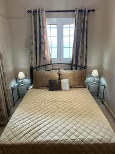 1 dormitorio con 1 cama grande y 2 lámparas en Myrties House en Kalymnos