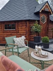 a cabin with two chairs and a table in front of it at Apple blossom glamping in Kilkenny