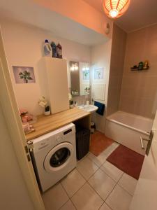 ein Badezimmer mit einer Waschmaschine und einer Badewanne in der Unterkunft Appartement meublé et cosy in Gennevilliers