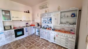 アルゲーロにあるB&B Jamba self ceck inの白いキャビネットと電化製品付きの広い白いキッチン