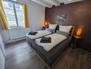 een slaapkamer met 2 bedden en een groot raam bij Residenz Vier Jahreszeiten Monschau in Monschau