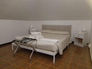 una camera da letto con un letto e un tavolo con asciugamani di La Maison Blanche a Borghesiana