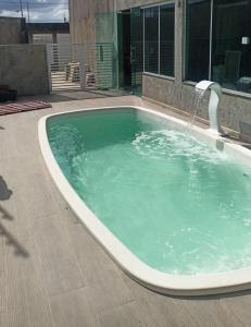 a large swimming pool with a water fountain at CASA COMPARTILHADA PERTINHO DO PARQUE ACAUÃ em Garanhuns - Leia atentamente a descricão do imóvel in Garanhuns