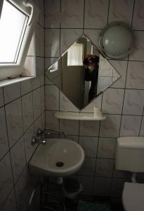 a person taking a picture of a bathroom mirror at Gospodarstwo Agroturystyczne Kłączno in Kłaczno