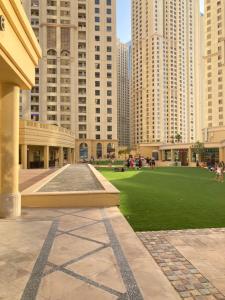 a park in the middle of a city with tall buildings at Jumeirah Beach Residence in Dubai