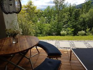 a wooden table and chairs on a patio with a view at Exklusiver Souterrain - zentral, ruhig mit großer Terrasse, Bergblick und privaten Sauna zzgl in Immenstadt im Allgäu