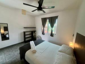 a bedroom with a bed with a ceiling fan at Hotel Aqualuna Cyclops in Brisas de Zicatela +1 photo