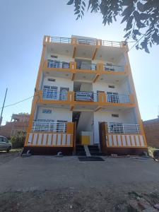 um edifício com varandas cor-de-laranja ao lado em HOTEL RAMAYAN INN FREE PICKUP FROM AYODHYA DHAM RAILWAY STATION em Ayodhya