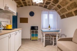 una cucina e un soggiorno con un tavolo e un divano di Casa Donosa al centro storico ad Alghero