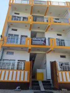 budynek z pomarańczowymi balkonami i znakiem na nim w obiekcie HOTEL RAMAYAN INN FREE PICKUP FROM AYODHYA DHAM RAILWAY STATION w mieście Ayodhya
